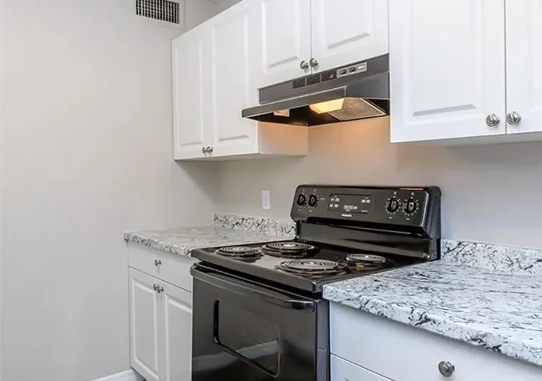 kitchen with white cabinets and black stove at The  Element At 464